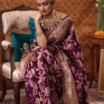 Woman wearing a peach orange Banarasi silk saree with floral zari motifs