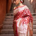 Woman wearing a purple Banarasi silk saree with golden zari work